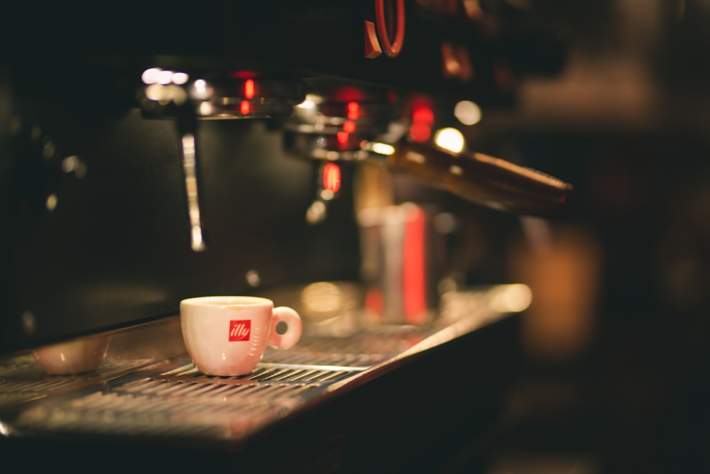 white ceramic cup on silver coffee machine