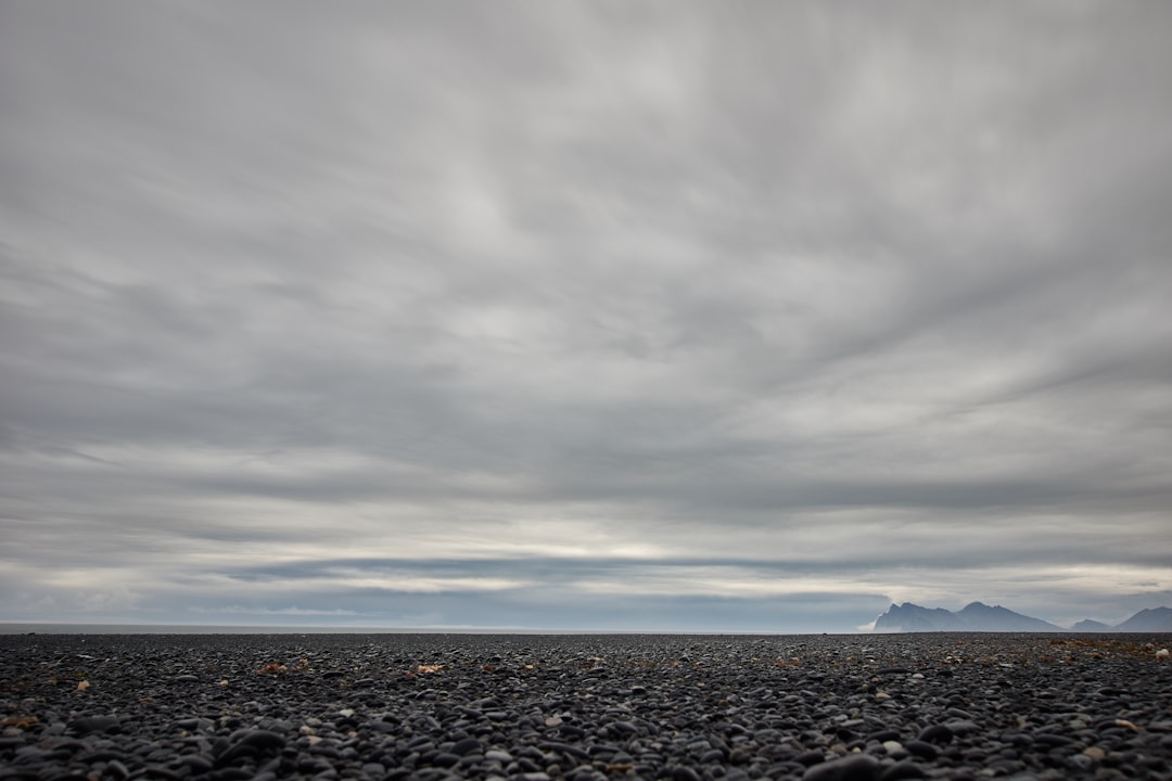 black and white stones on beach under gray cloudy sky