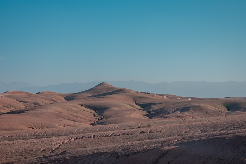 brown sand field under blue sky during daytime