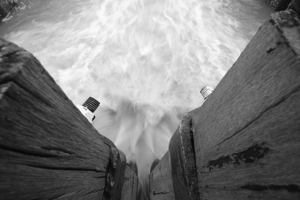 grayscale photo of a man standing on a wooden dock