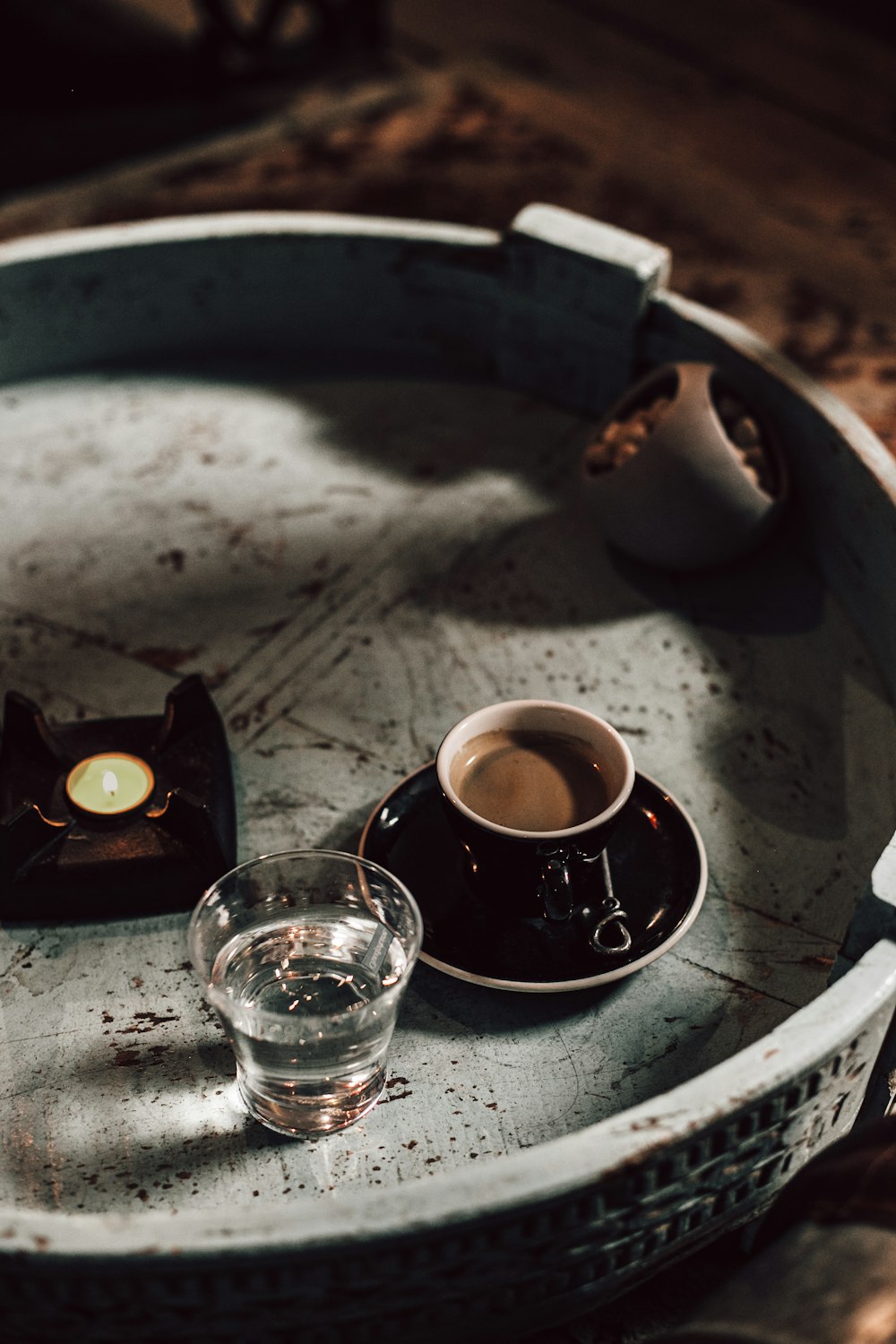 clear drinking glass beside white ceramic teacup on saucer