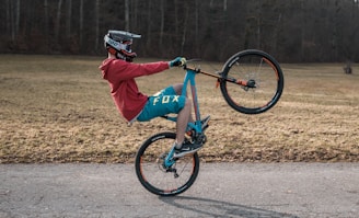 man in red jacket riding blue bmx bike