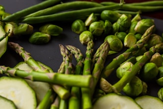 Close-up of vibrant fresh vegetables arranged artistically on a dark surface.