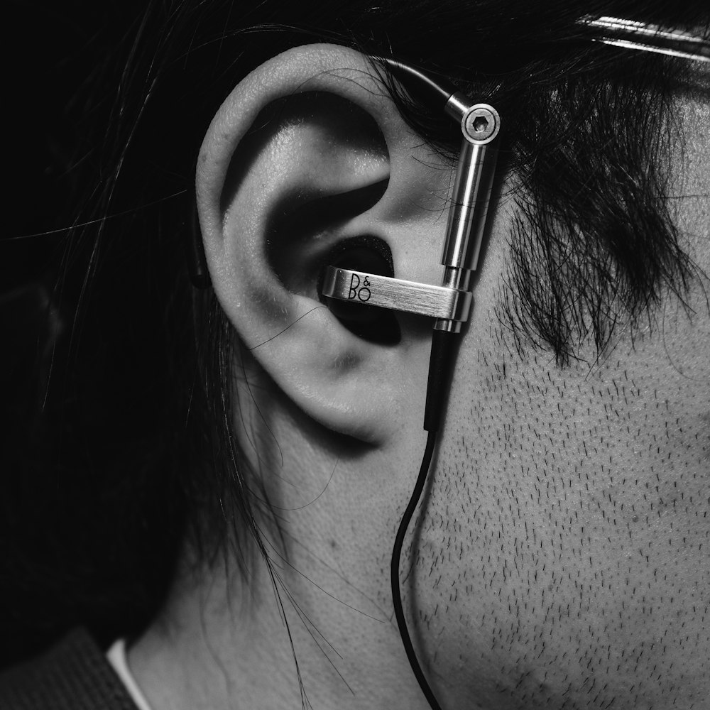 grayscale photo of woman with black earbuds