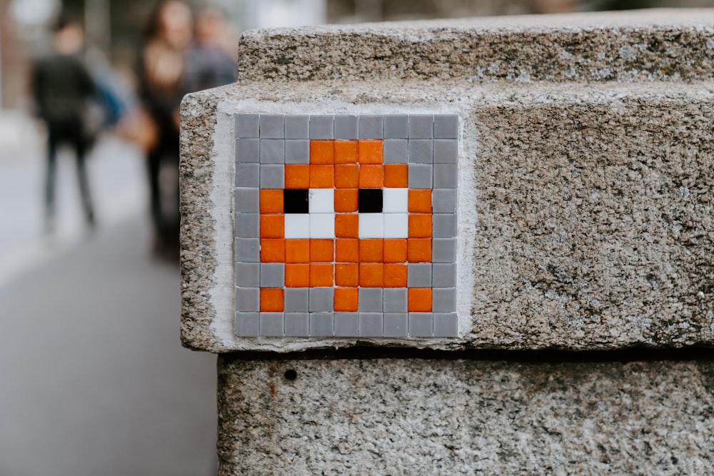 white and orange box on gray concrete wall