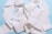 A tangled heap of white paper towel or tissue strips set against a light blue background. The paper appears textured and creates a complex pattern with folds and layers.