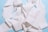 A tangled heap of white paper towel or tissue strips set against a light blue background. The paper appears textured and creates a complex pattern with folds and layers.