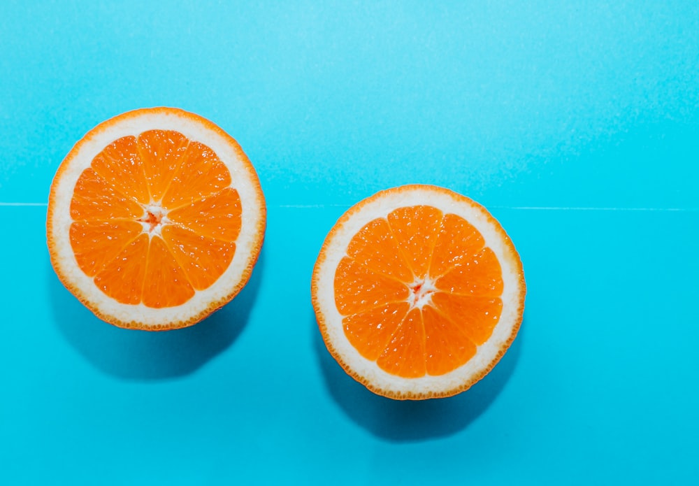 sliced orange fruit on blue surface