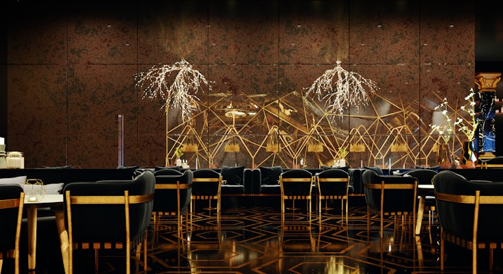 A luxurious and sophisticated interior space featuring elegant dining tables and chairs with black upholstery and wooden accents. The walls have a reflective, geometric design with intricate, illuminated floral decorations. The floor showcases a polished, patterned surface, contributing to the high-end atmosphere.