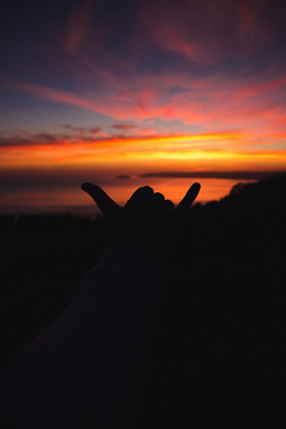 silhouette of persons hand during sunset