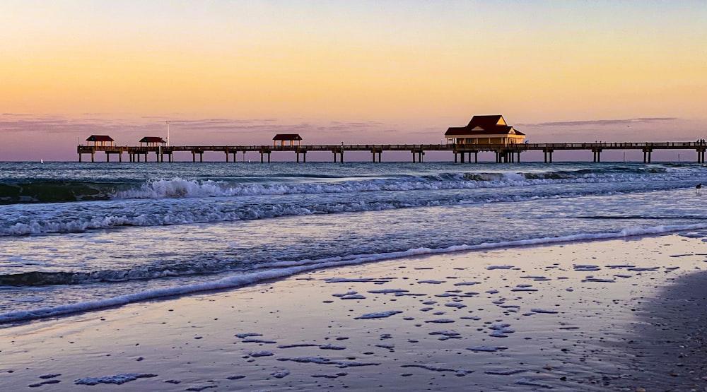 brown wooden dock on sea during sunset