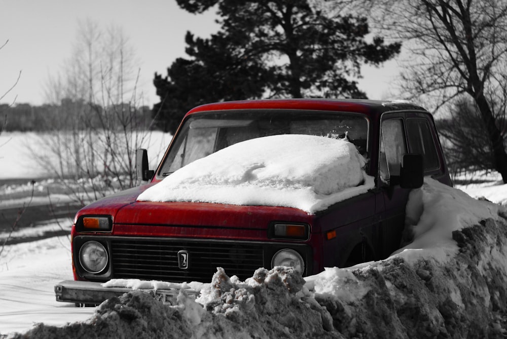 red car on snow covered ground during daytime