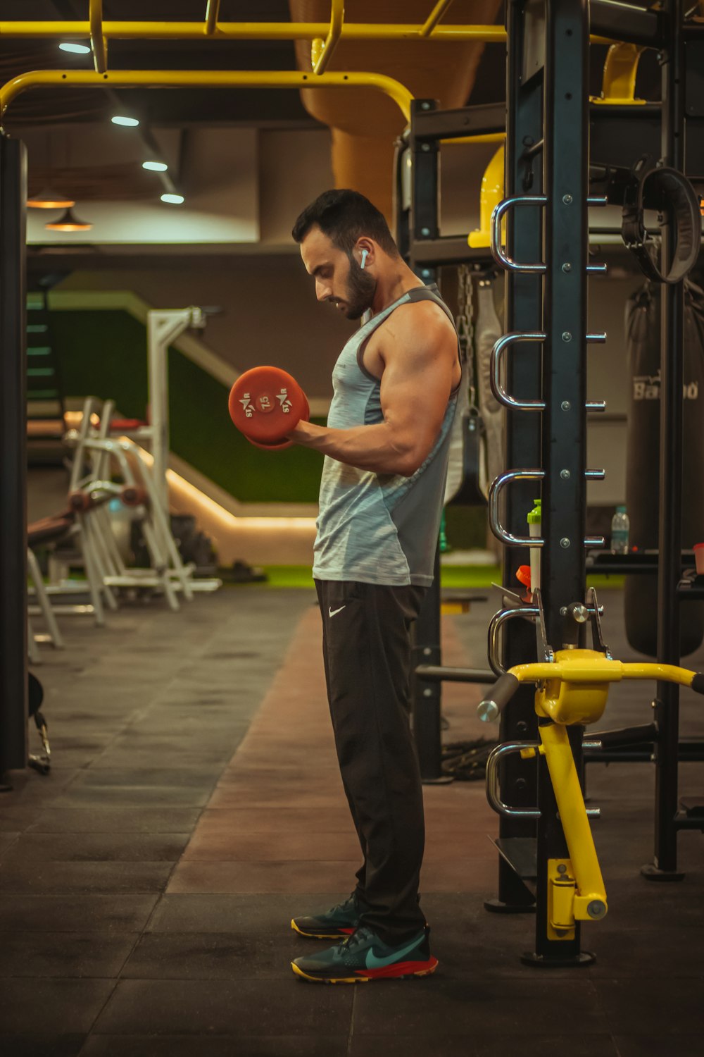 man in gray tank top and gray pants holding red basketball