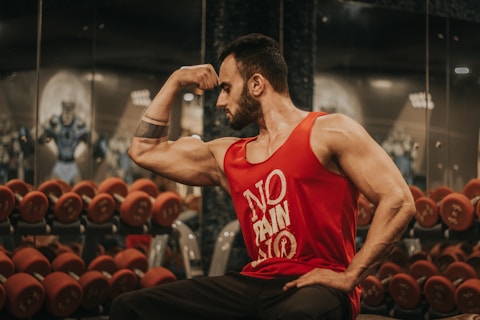 man in red tank top sitting on chair