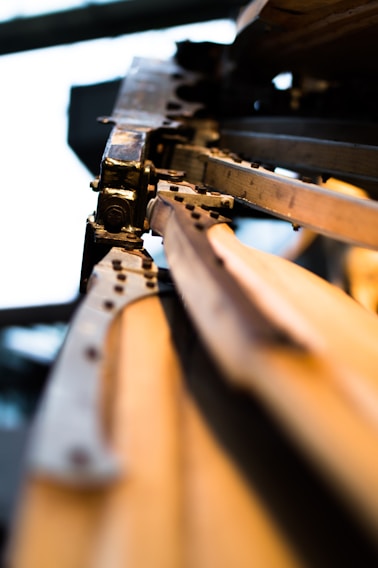A close-up view of a mechanical structure featuring a series of metallic components, including rivets and beams. The perspective is angled, emphasizing the details in the metalwork and creating a sense of depth.