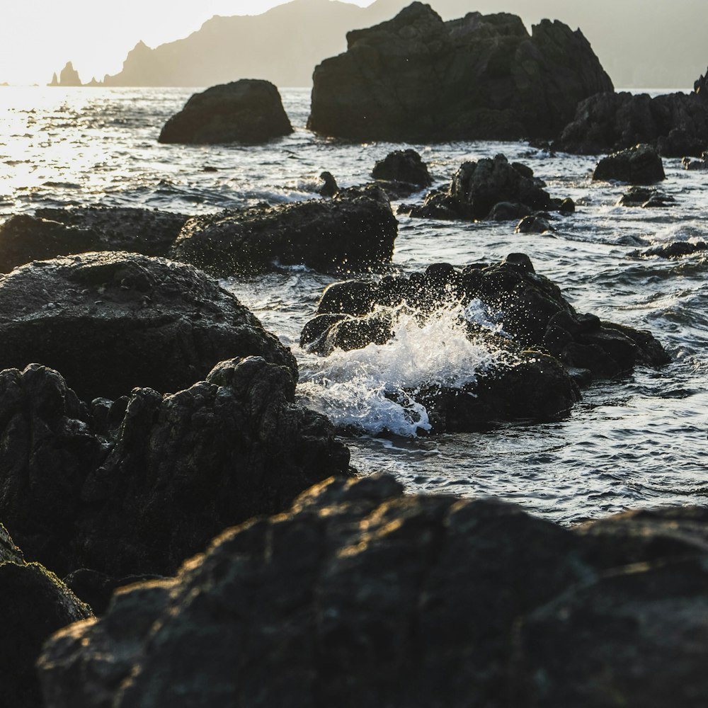 black rock formation on sea during daytime