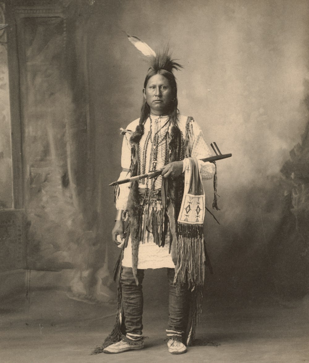 man in black jacket holding a stick