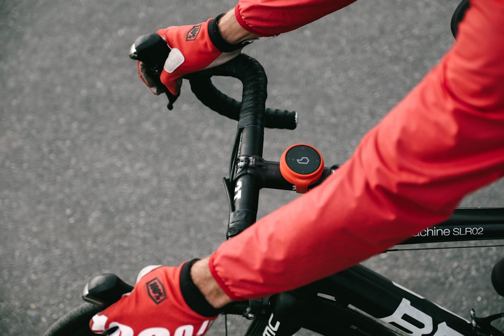 person in red pants riding black bicycle during daytime