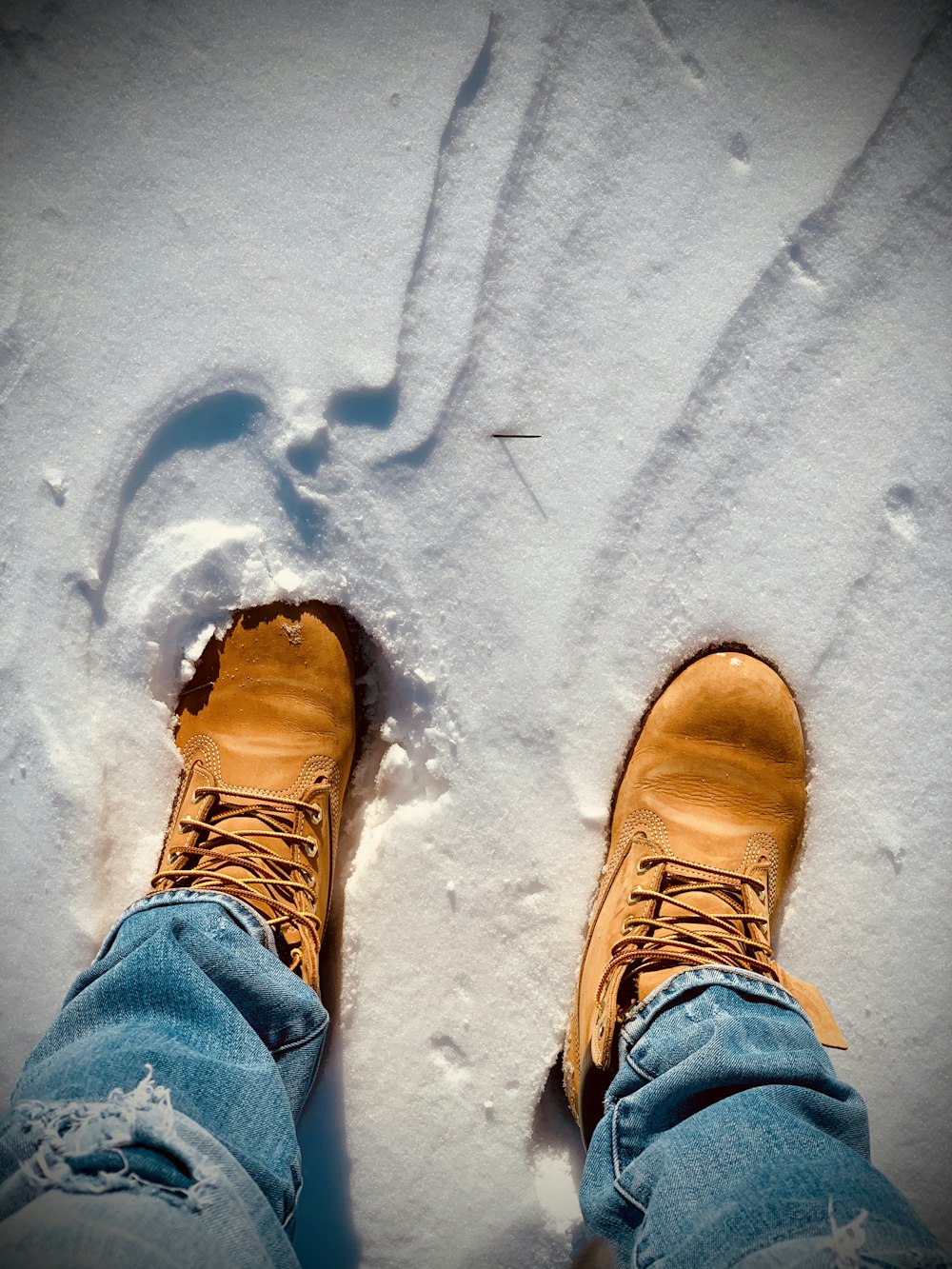 person in blue denim jeans and brown hiking shoes