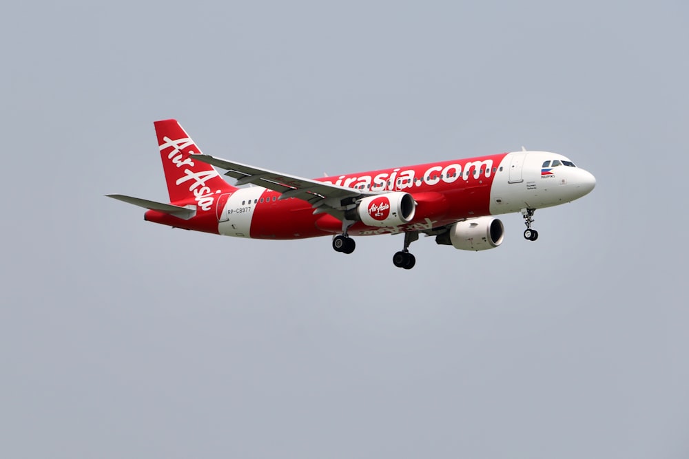 red and white passenger plane in flight