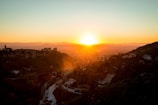 A sunset over a historic castle overlooking the landscape.