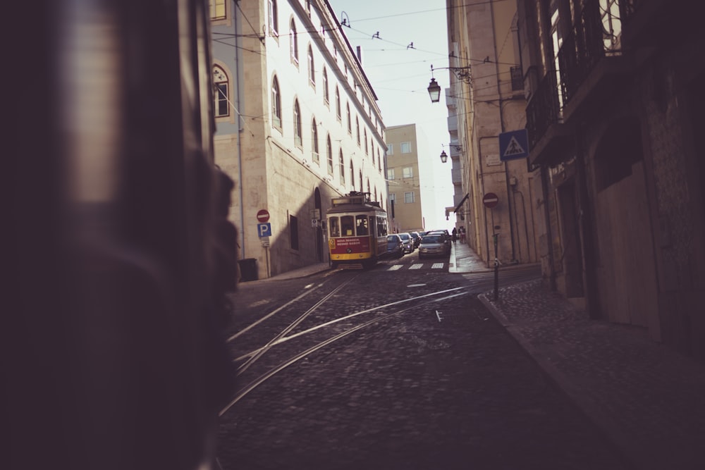 cars on road between buildings during daytime