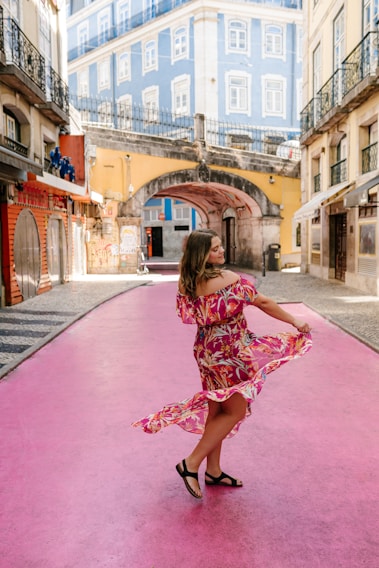 A stylish woman wearing a flowing dress in a vibrant urban setting.