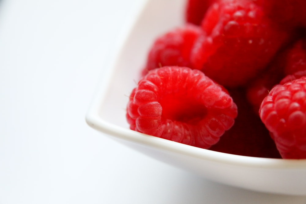 red raspberry on white ceramic bowl