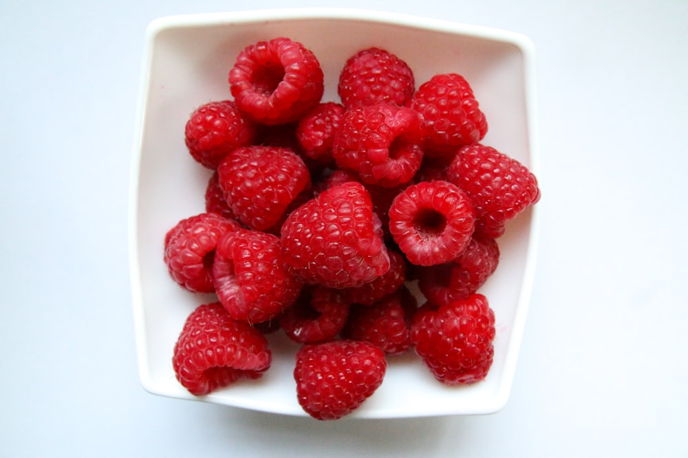 red strawberries on white ceramic bowl