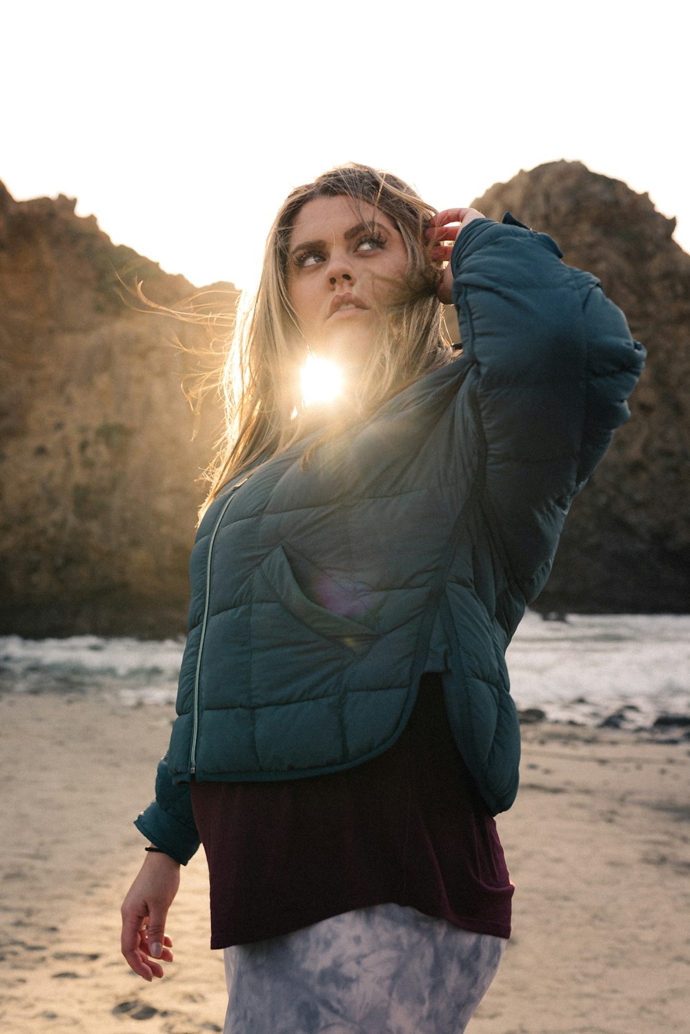 woman in gray jacket standing on beach during daytime