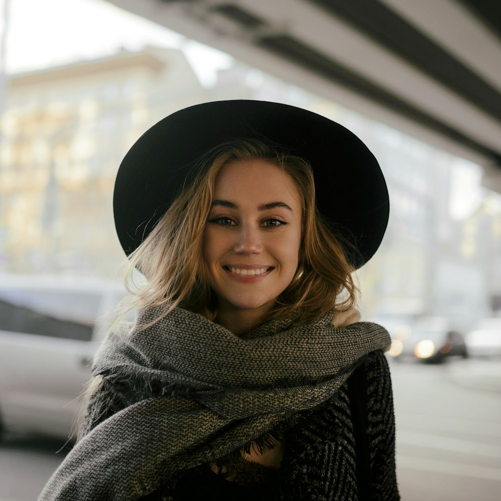 smiling woman wearing black hat and scarf