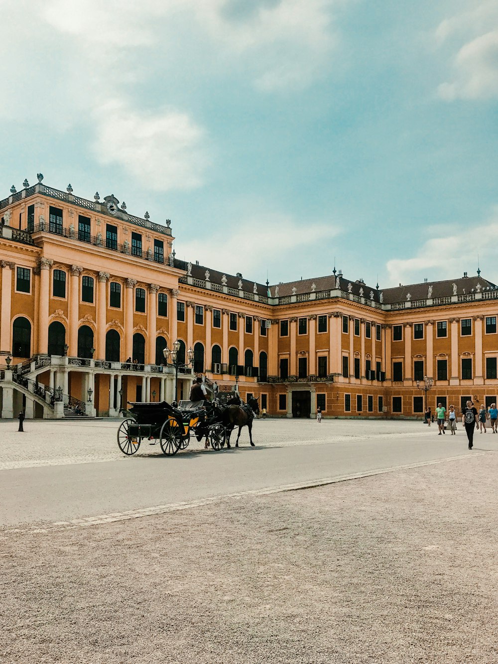 people riding on horse near brown building during daytime