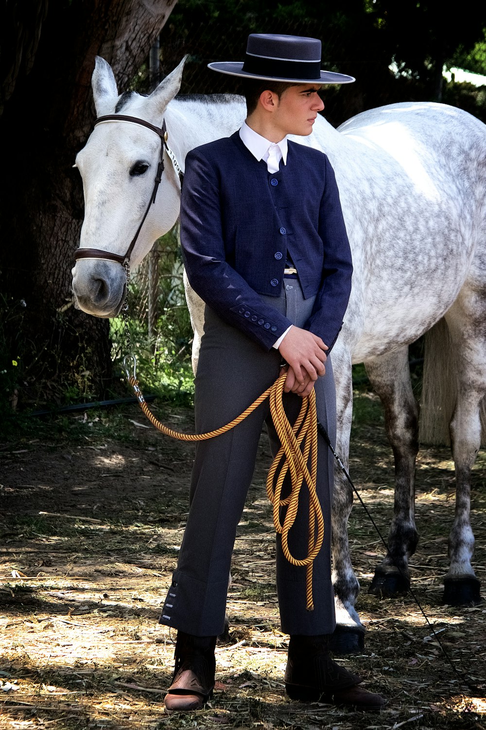 woman in blue denim jacket standing beside white horse