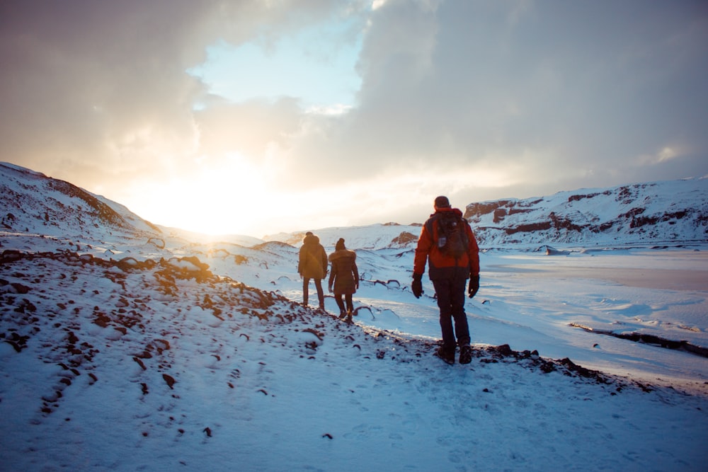 man in blue jacket and black pants standing on snow covered ground during daytime