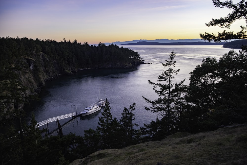 white boat on body of water during sunset