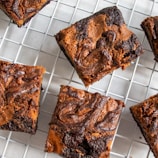 a bunch of brownies sitting on top of a cooling rack