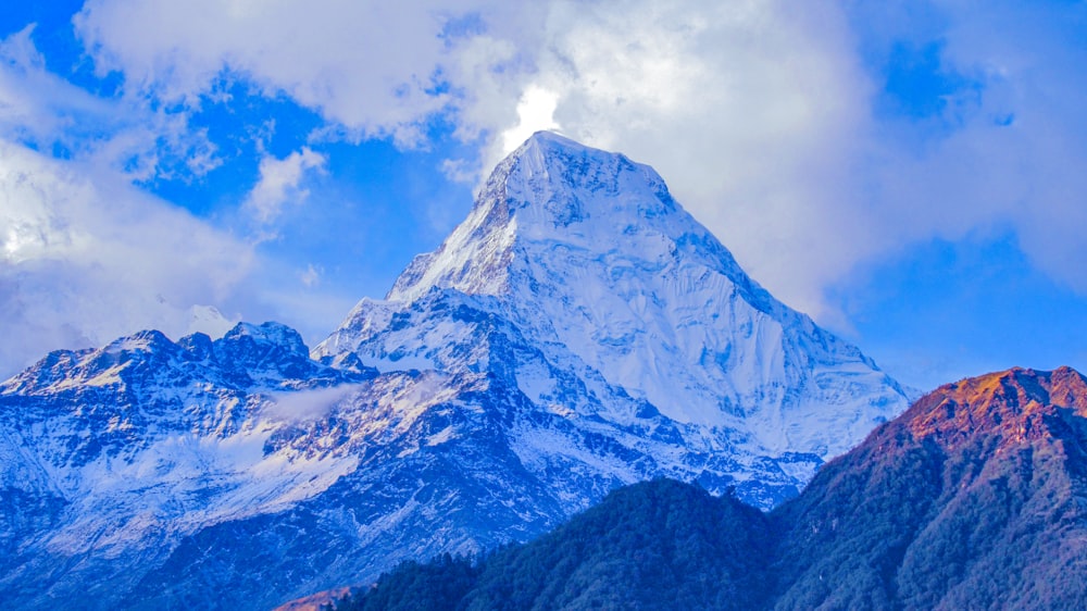 snow covered mountain under cloudy sky during daytime