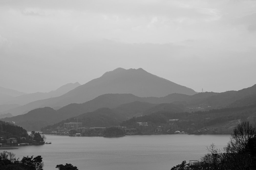 grayscale photo of mountain near body of water