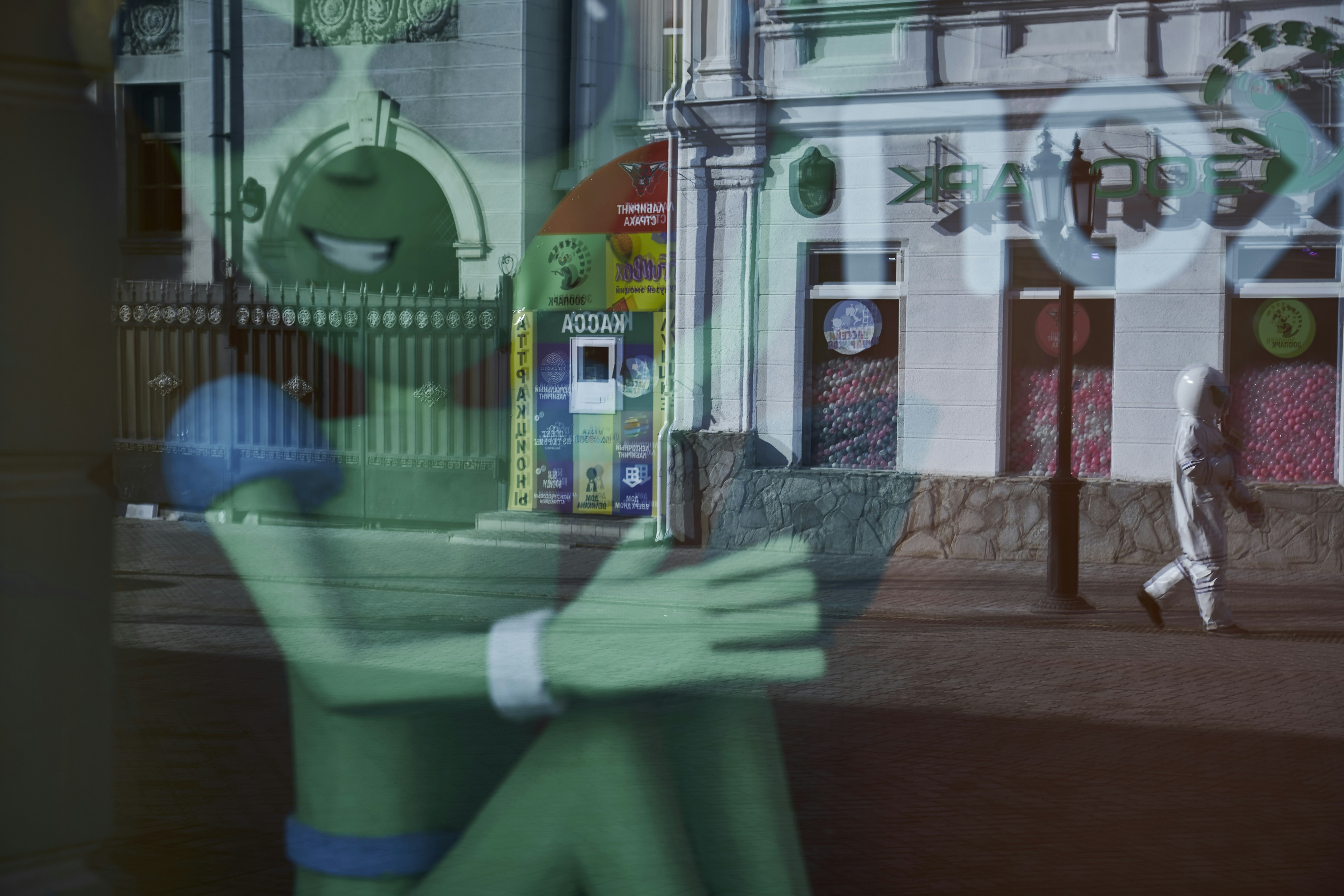 green plastic trash bin near white and red concrete building