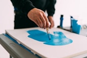 person holding blue paint brush