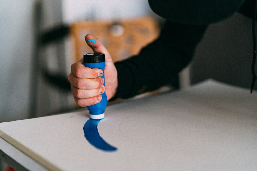 person holding blue and black plastic toy