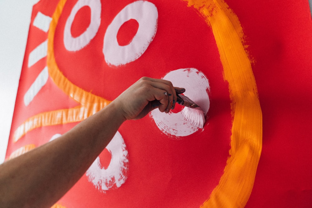 person holding white and red round plate