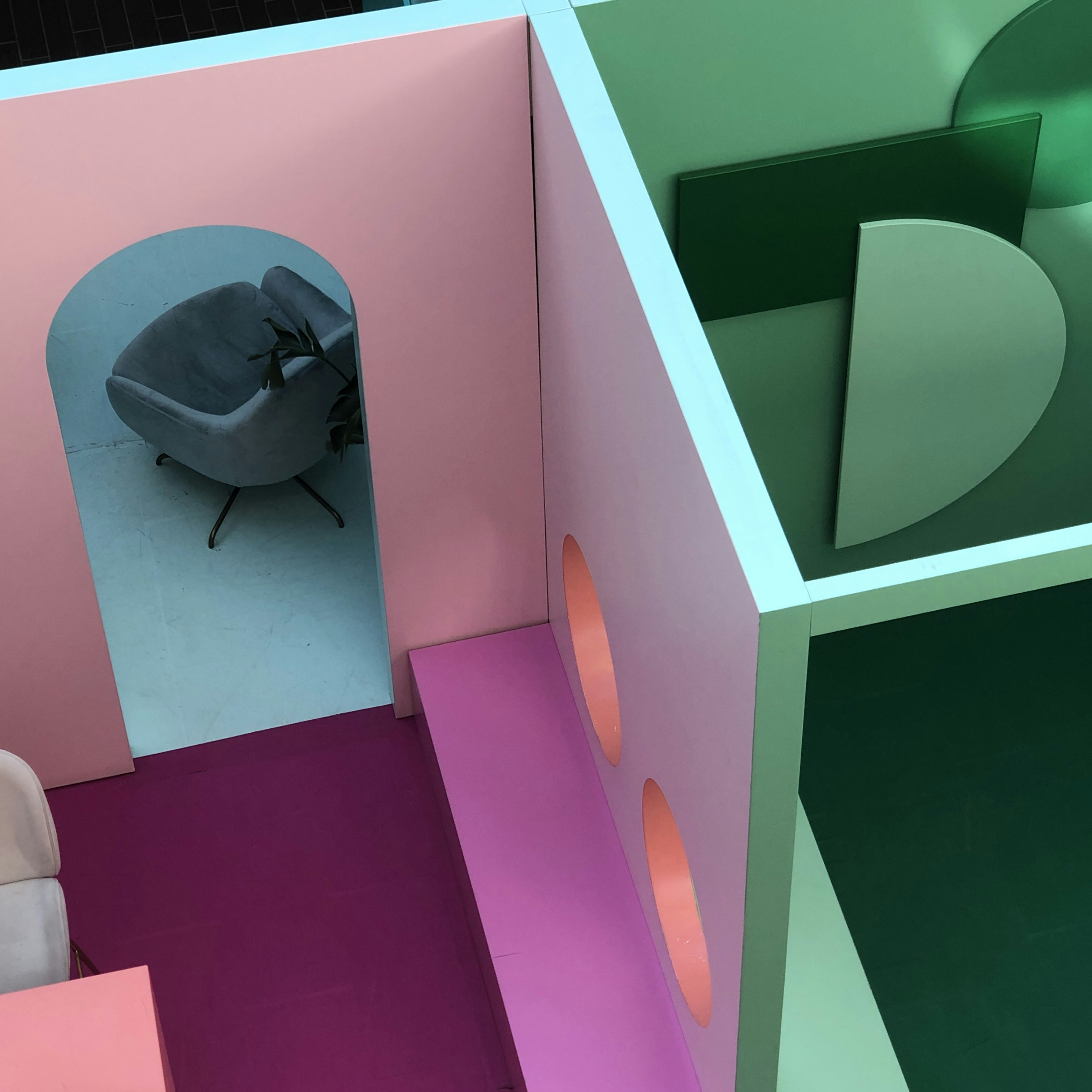 schwarze Ledertasche auf rosa und grüner Treppe