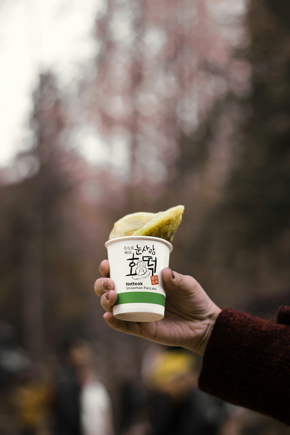 person holding white and yellow plastic cup