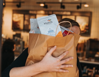 person holding brown paper bag