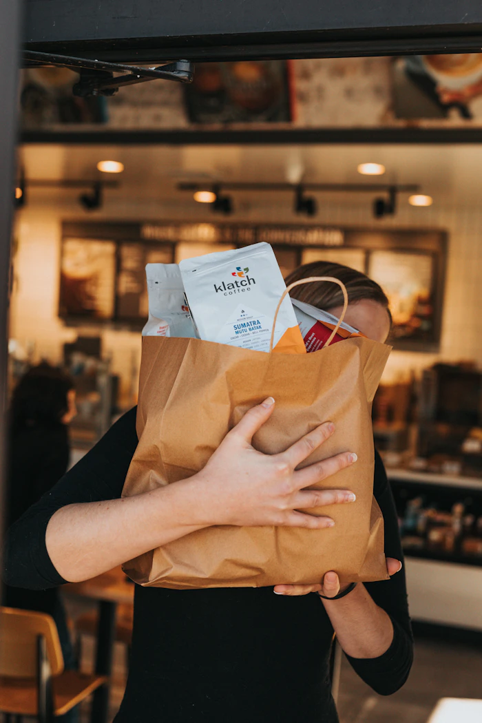 Person holding a brown paper bag