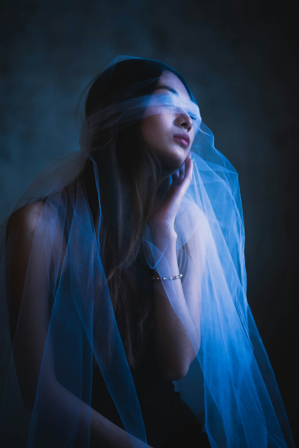 woman in blue hijab and silver necklace