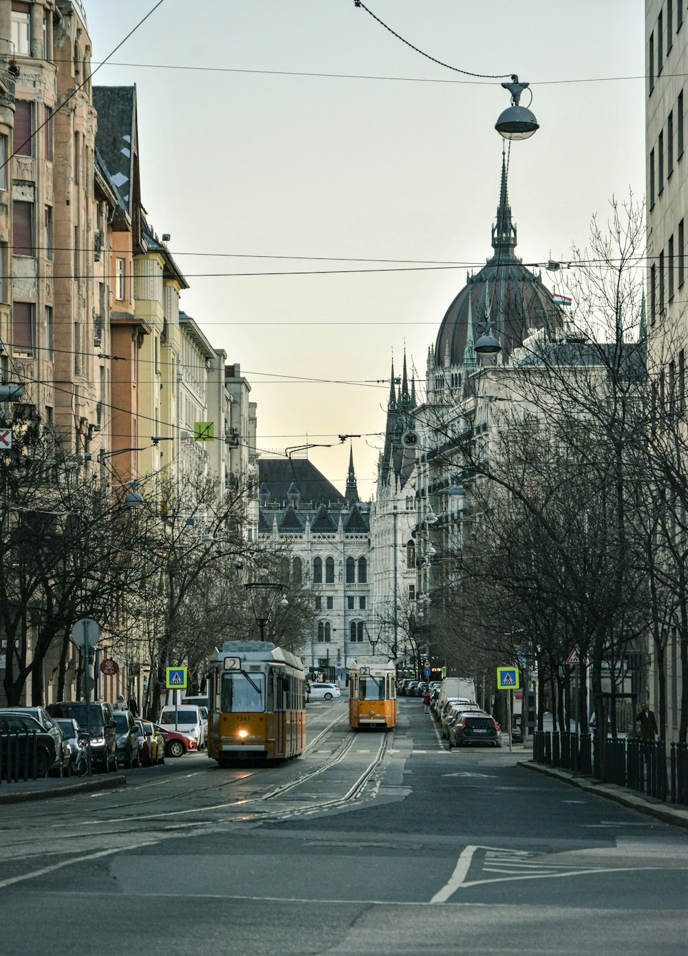 yellow and black bus on road near white concrete building during daytime