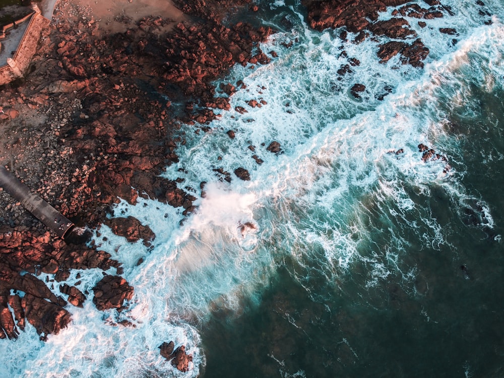 ocean waves crashing on rocks during daytime