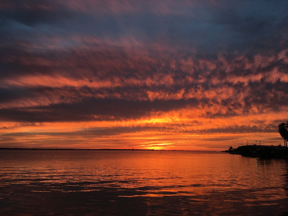 silhouette of boat on sea during sunset